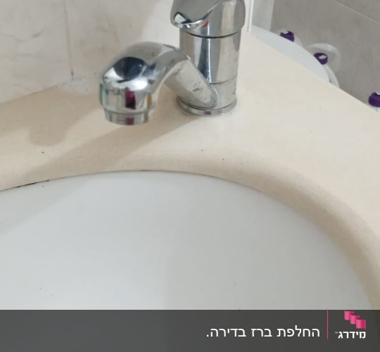 ברז כרום מותקן על כיור אמבטיה לבן